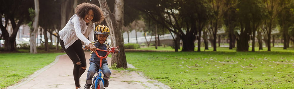 Woman helping child on bike