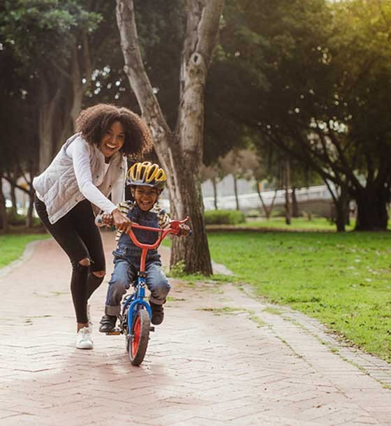 Woman helping child on bike