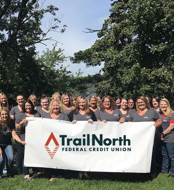 Employees holding TrailNorth banner