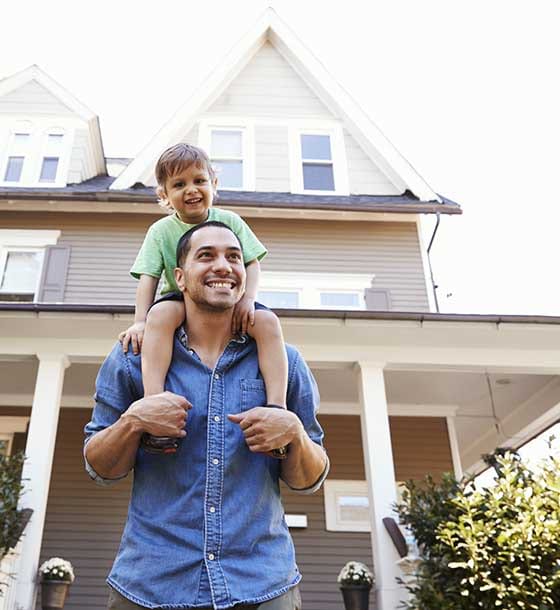 Man and child in front of house