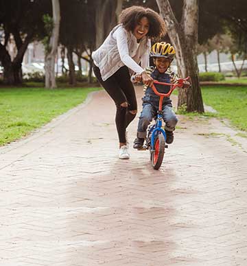 Woman helping child on bile