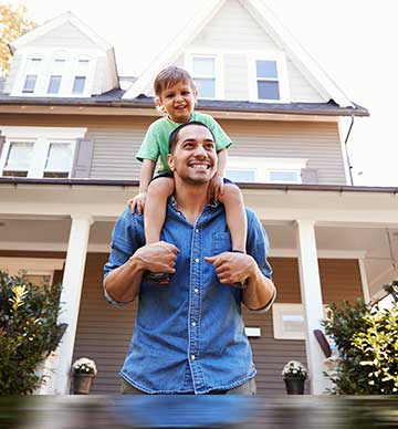 Man and child in front of house