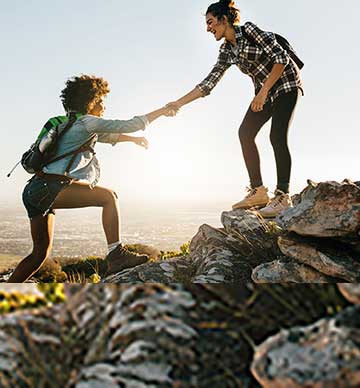 Friends helping climb a mountain